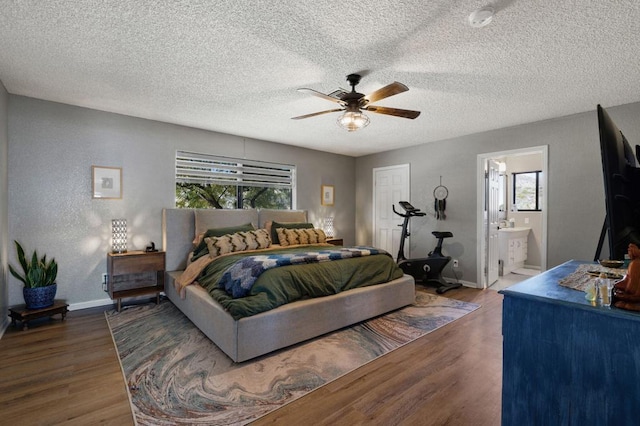 bedroom with a textured ceiling, ensuite bath, ceiling fan, and dark hardwood / wood-style floors