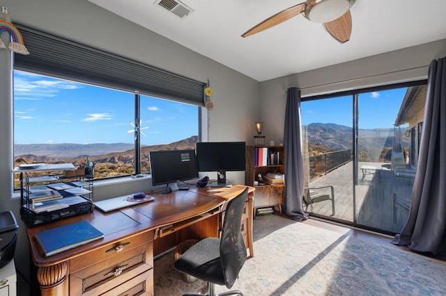 carpeted office space featuring plenty of natural light and ceiling fan