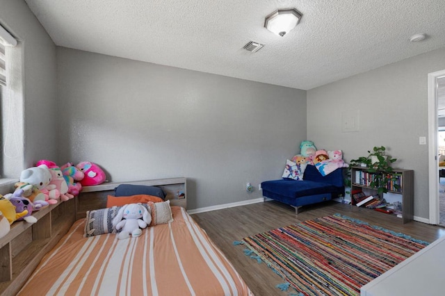 bedroom featuring wood-type flooring and a textured ceiling