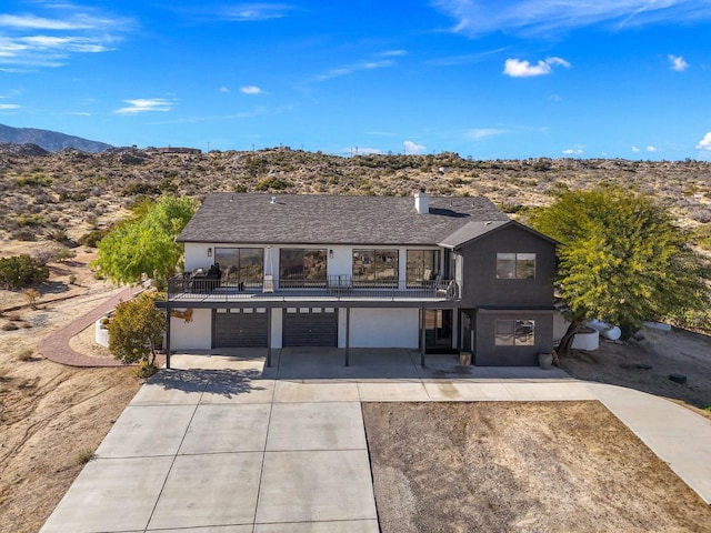 view of front of home with a mountain view, a balcony, and a garage