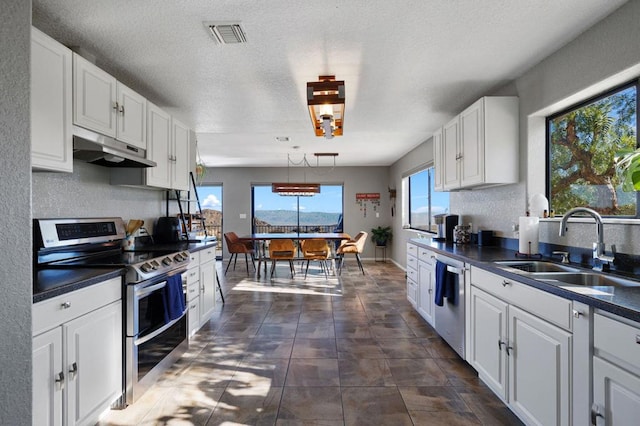 kitchen with sink, stainless steel appliances, pendant lighting, a textured ceiling, and white cabinets