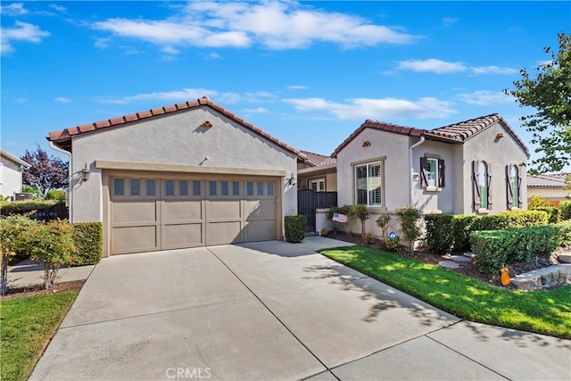 mediterranean / spanish-style house featuring a front yard and a garage