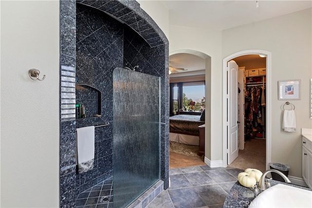 bathroom featuring vanity, tile patterned flooring, and a tile shower