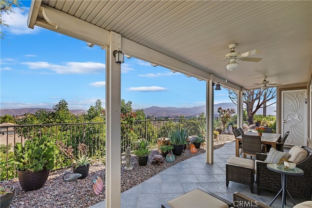 view of patio with ceiling fan and a mountain view