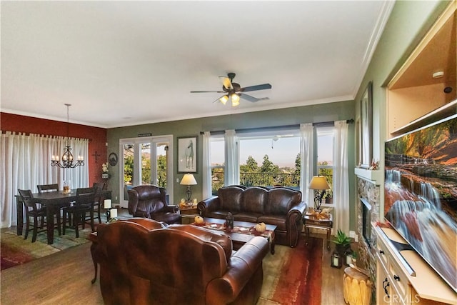 living room featuring ornamental molding, ceiling fan with notable chandelier, and dark wood-type flooring