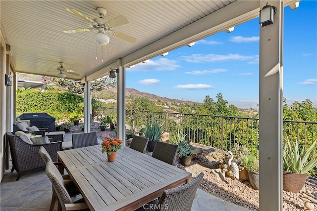 view of patio featuring a mountain view, ceiling fan, and grilling area