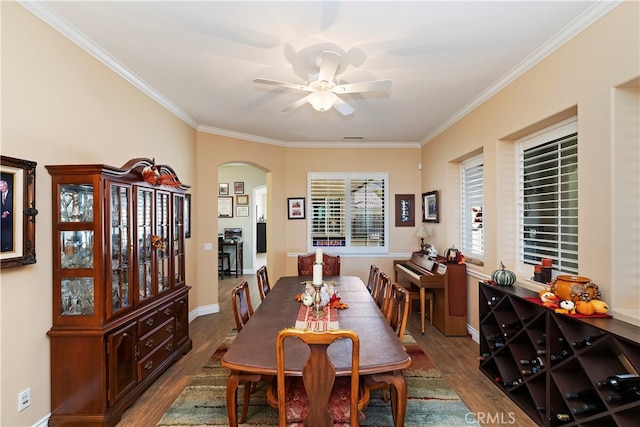 dining space featuring dark wood-type flooring, ornamental molding, and ceiling fan