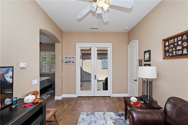 living room with ceiling fan and dark hardwood / wood-style flooring