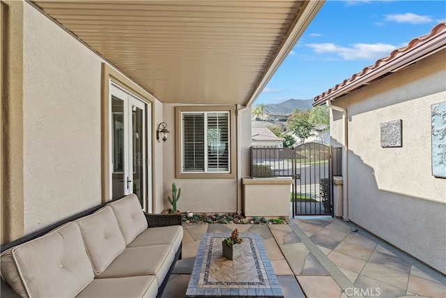 balcony featuring an outdoor living space, a mountain view, and a patio