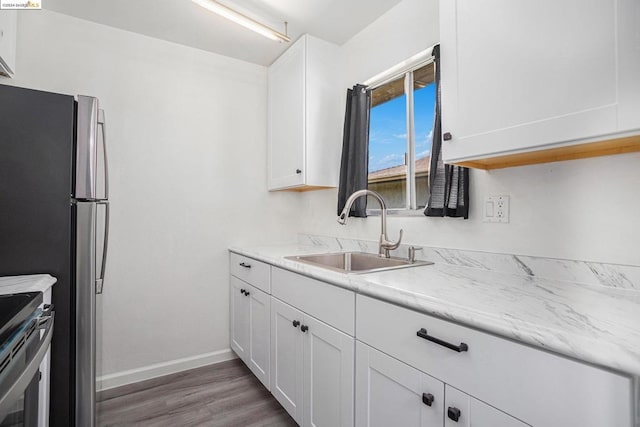 kitchen with white cabinets, wood-type flooring, stainless steel appliances, and sink