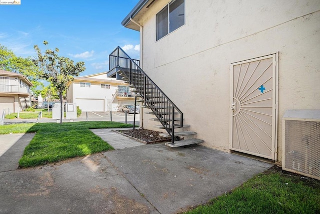 exterior space with central AC and a lawn