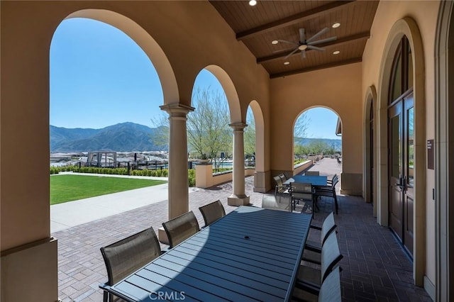 view of patio with ceiling fan and a mountain view