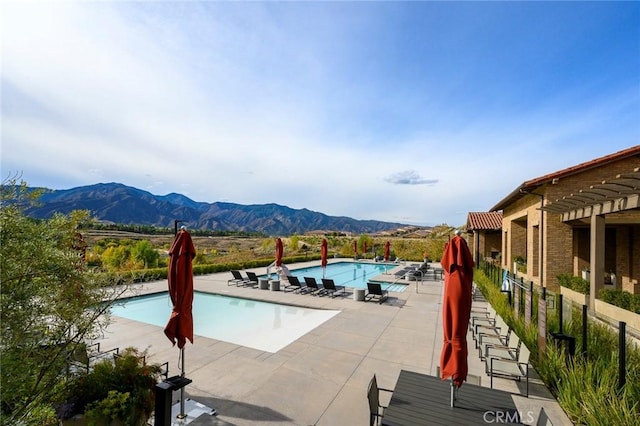 view of pool with a mountain view and a patio