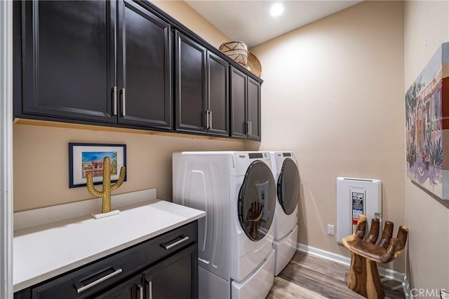 laundry room with cabinets, separate washer and dryer, and light hardwood / wood-style flooring