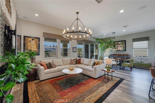 living room featuring a chandelier, hardwood / wood-style floors, and a wealth of natural light