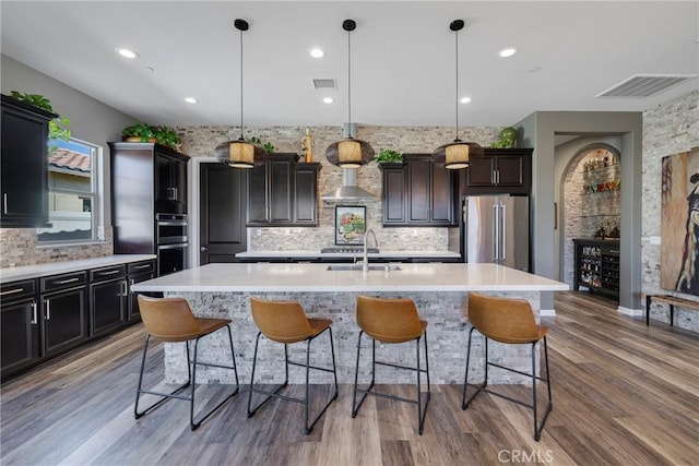 kitchen featuring a center island with sink, pendant lighting, sink, and appliances with stainless steel finishes