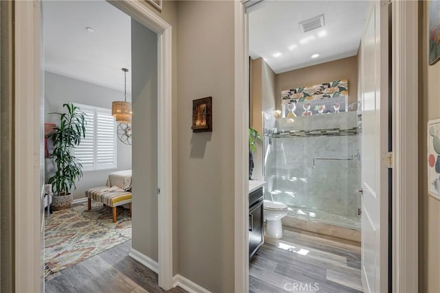 bathroom featuring vanity, hardwood / wood-style flooring, toilet, and an enclosed shower