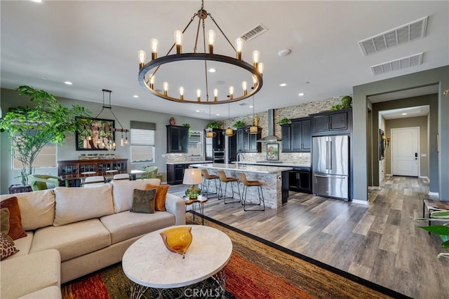 living room with hardwood / wood-style floors, a chandelier, and sink