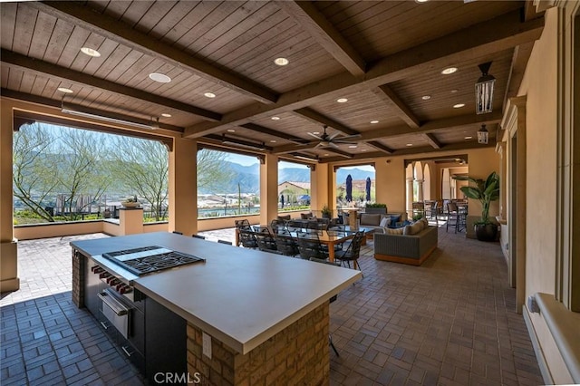 view of patio / terrace featuring an outdoor living space, ceiling fan, a bar, and a mountain view