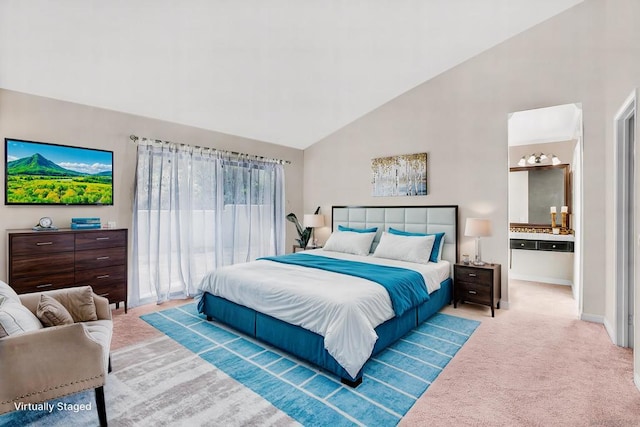 carpeted bedroom featuring ensuite bathroom and high vaulted ceiling