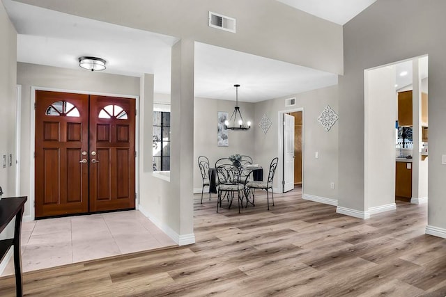 entrance foyer featuring light hardwood / wood-style floors and a notable chandelier