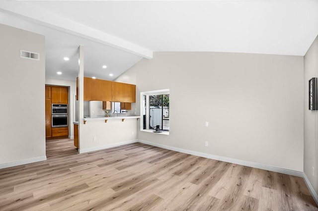 unfurnished living room with high vaulted ceiling, light wood-type flooring, beam ceiling, and sink