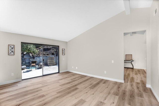 empty room featuring vaulted ceiling with beams and light hardwood / wood-style floors