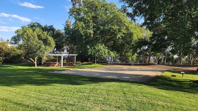 view of property's community featuring a yard and volleyball court