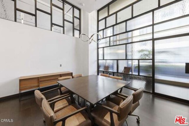 dining area featuring expansive windows and a towering ceiling