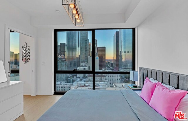 bedroom featuring light wood-type flooring and expansive windows