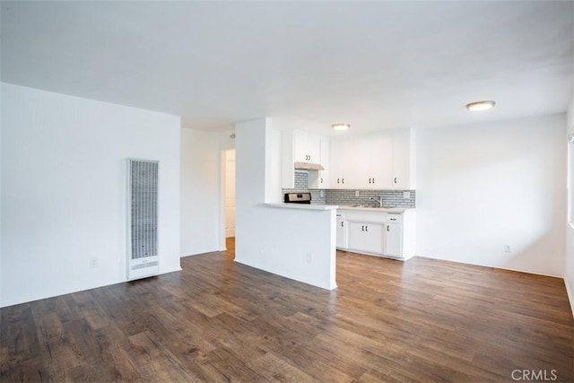 unfurnished living room with dark hardwood / wood-style flooring and sink