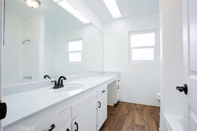 bathroom with plenty of natural light, vanity, wood-type flooring, and toilet