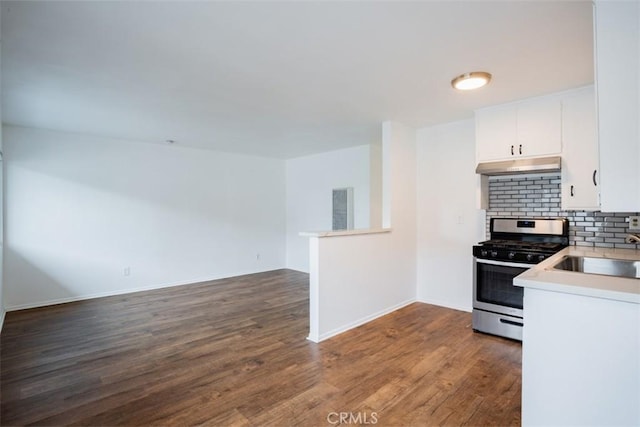 kitchen with white cabinets, sink, dark hardwood / wood-style floors, decorative backsplash, and gas stove