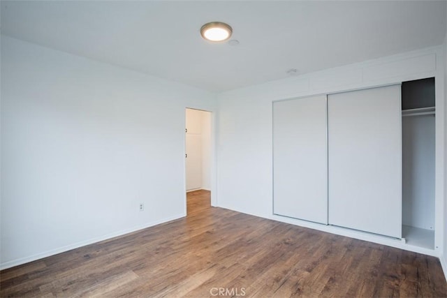 unfurnished bedroom with wood-type flooring and a closet