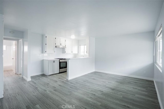 kitchen with white cabinets, stainless steel range with gas cooktop, and hardwood / wood-style flooring