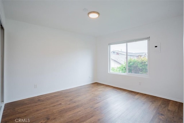 empty room with dark hardwood / wood-style flooring