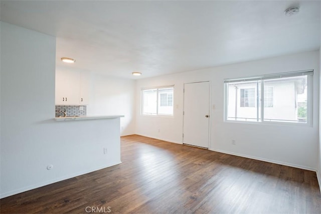 unfurnished living room with dark hardwood / wood-style flooring