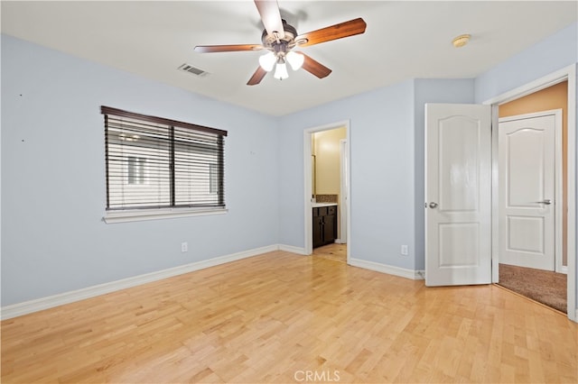 unfurnished bedroom with ceiling fan, a closet, light wood-type flooring, and ensuite bathroom