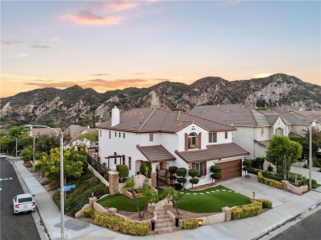 view of front of house featuring a mountain view, a yard, and a garage