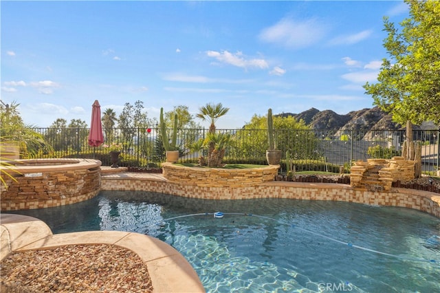 view of pool with a mountain view and an in ground hot tub