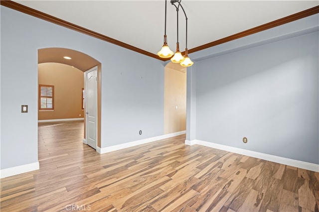 empty room featuring crown molding and light hardwood / wood-style flooring