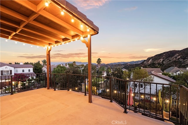 patio terrace at dusk with a balcony and a mountain view