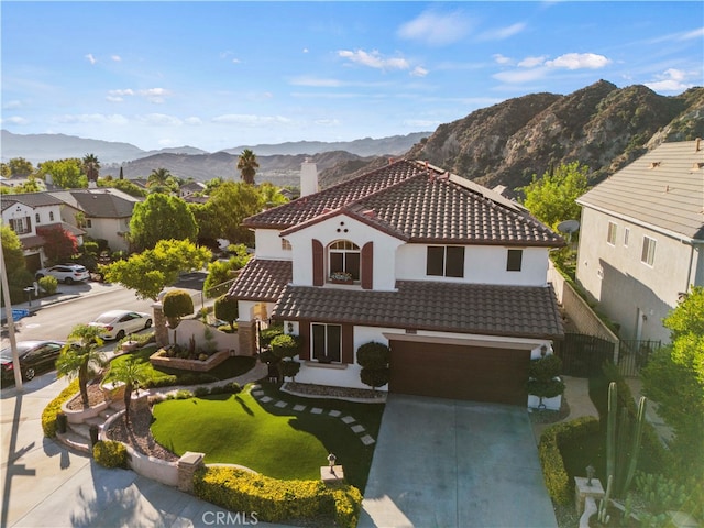 mediterranean / spanish home featuring a mountain view and a garage