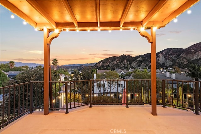 patio terrace at dusk featuring a mountain view