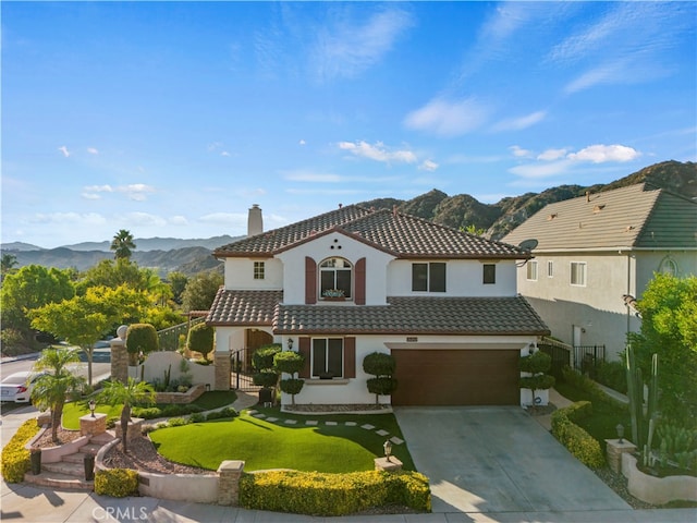 mediterranean / spanish house featuring a garage and a mountain view