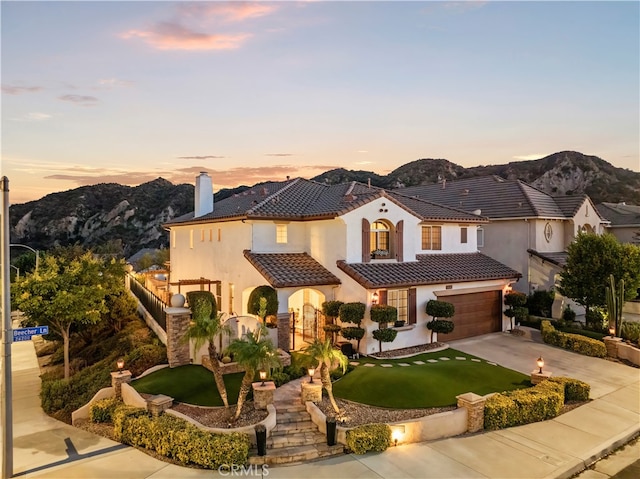 mediterranean / spanish house with a garage and a mountain view