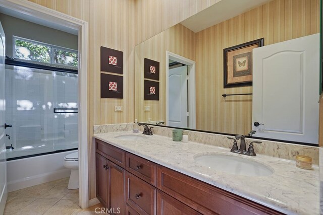 full bathroom with vanity, combined bath / shower with glass door, tile patterned flooring, and toilet