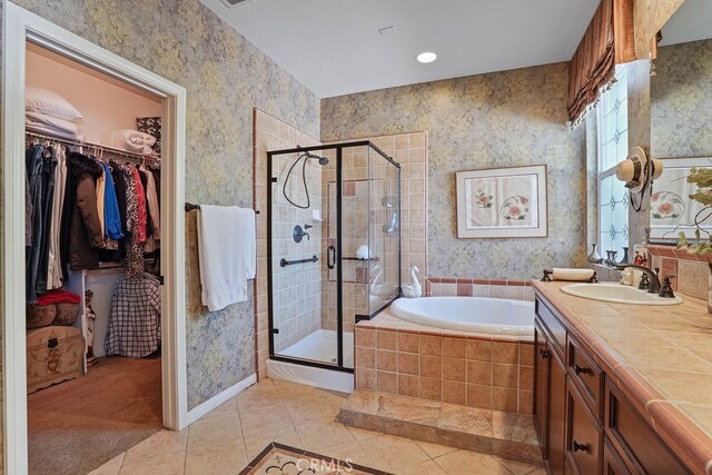 bathroom with tile patterned flooring, vanity, and plus walk in shower