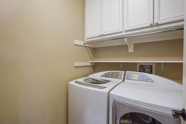 washroom featuring separate washer and dryer and cabinets