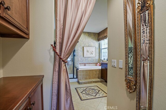 bathroom featuring a relaxing tiled tub and tile patterned floors